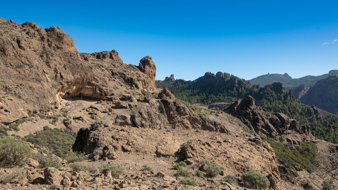 Die Felsenlandschaft am Montaña del Aserrador zeigt sich mit dem Pico de las Nieves im Hintergrund, der höchsten Erhebung Gran Canarias.