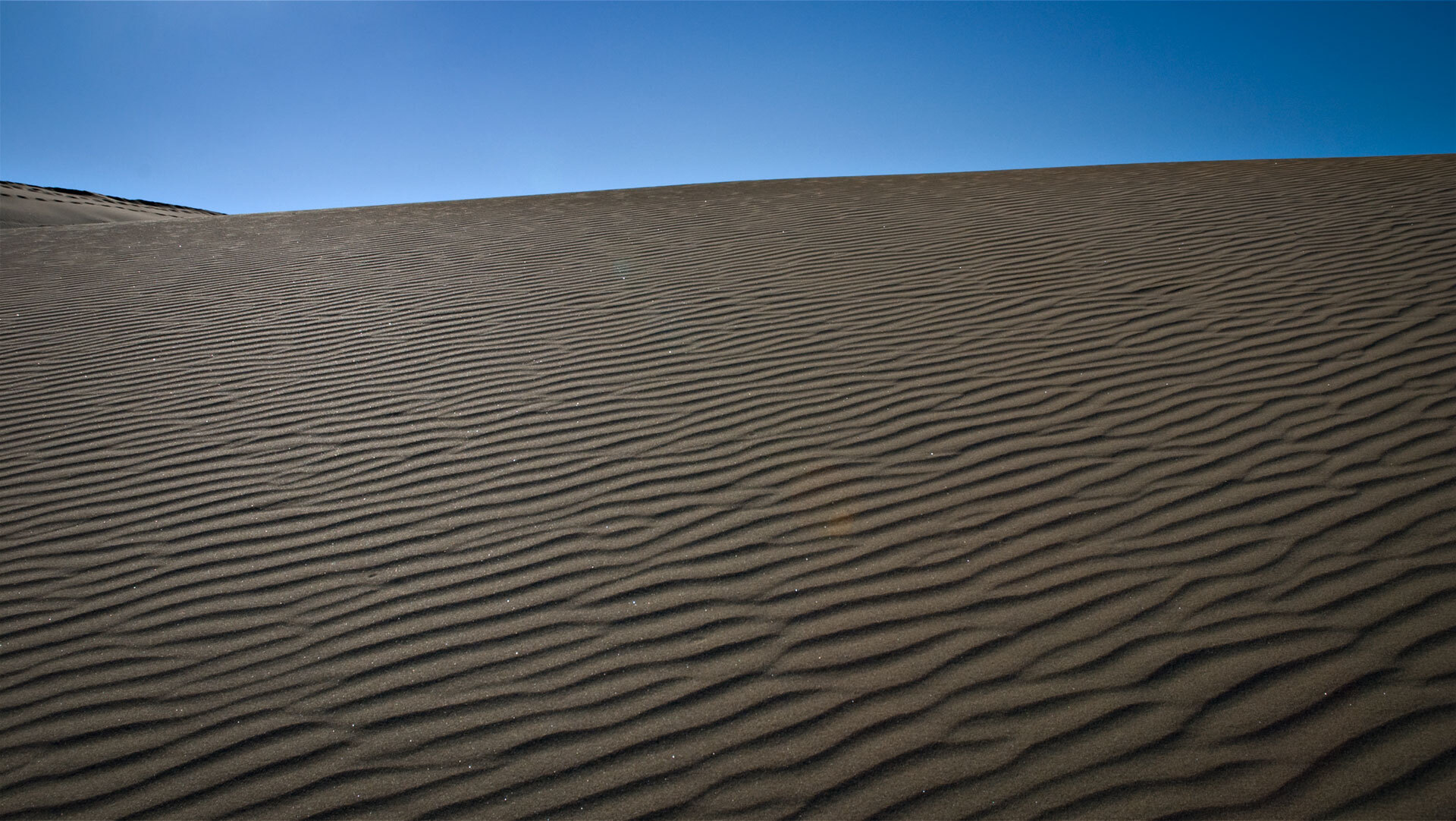 Der Wind zeichnet feine Muster in den Sand der Dünen von Maspalomas.