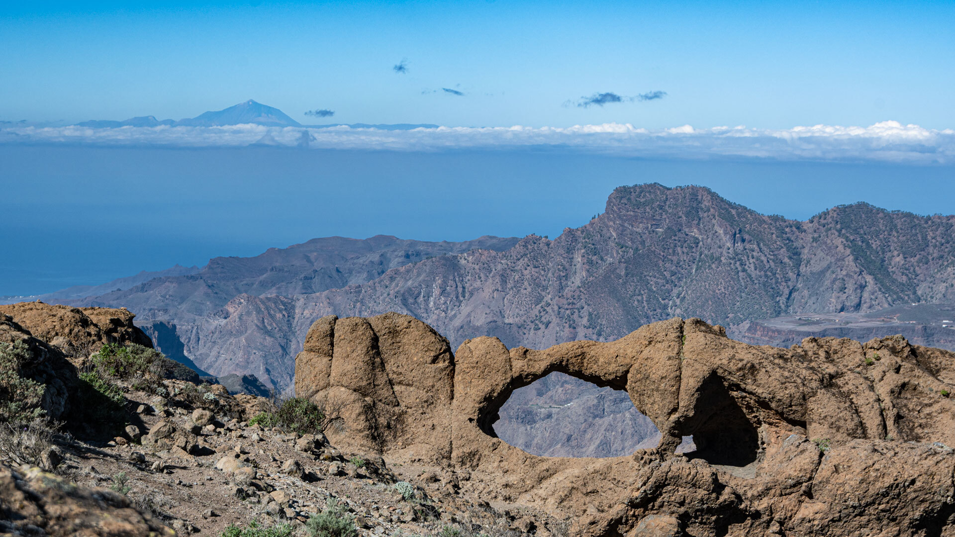 Vom Arco Aserrador schweift der Blick über die Montaña Altavista, während sich am Horizont die Silhouette Teneriffas abzeichnet